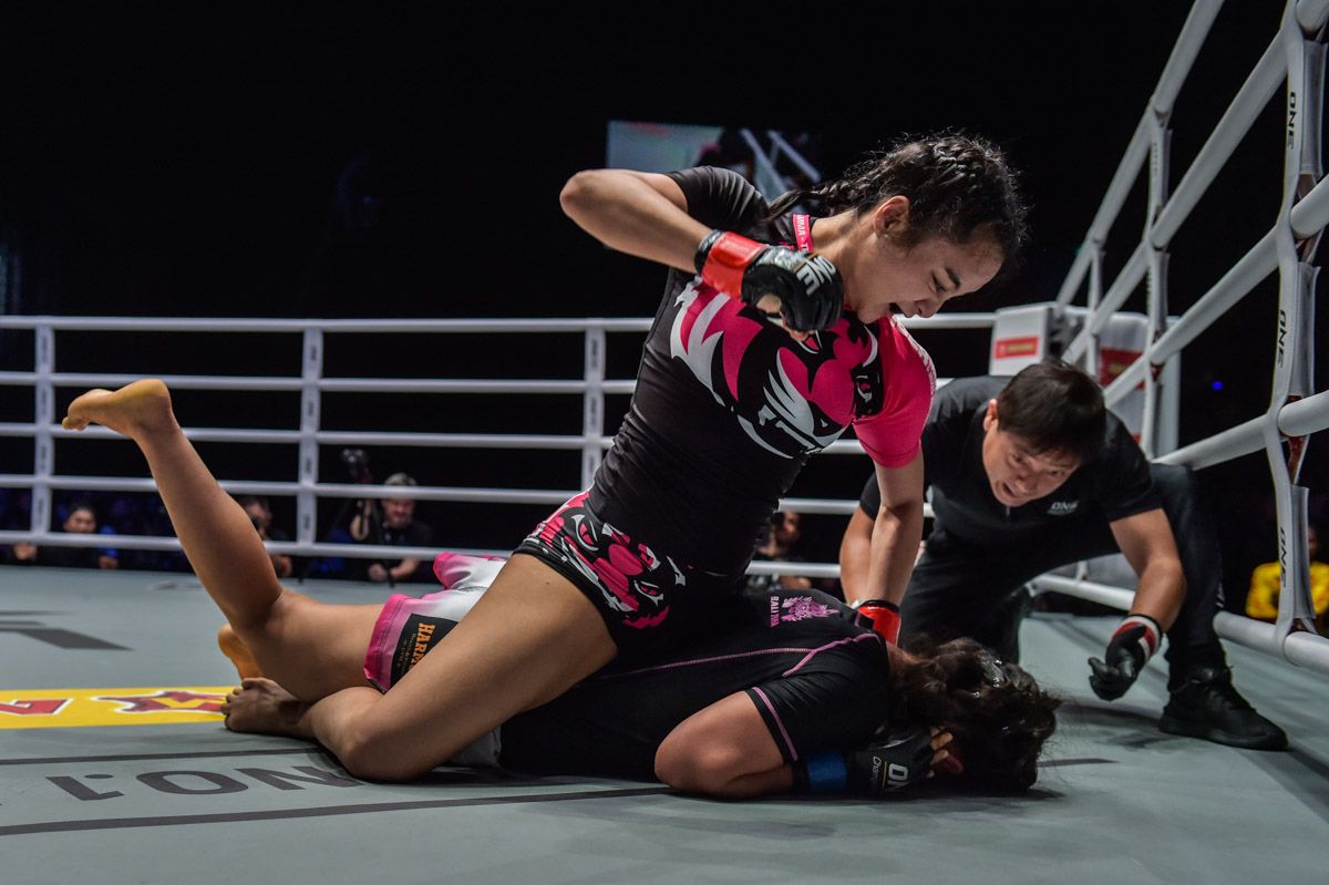 Thai mixed martial atist Rika Ishige punches her opponent with ground and pound