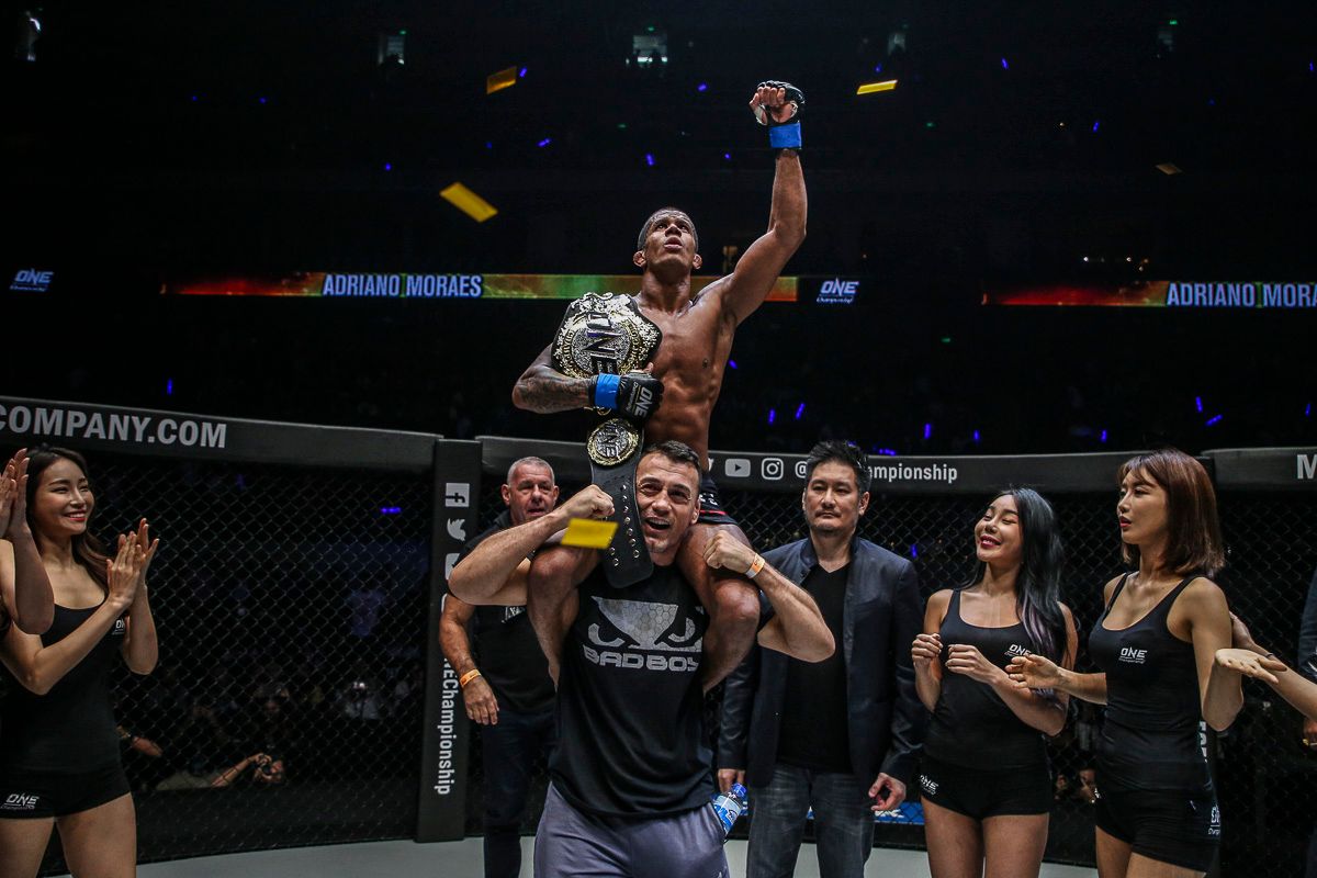 ONE Flyweight World Champion Adriano Moraes is raised upon his cornerman's shoulders