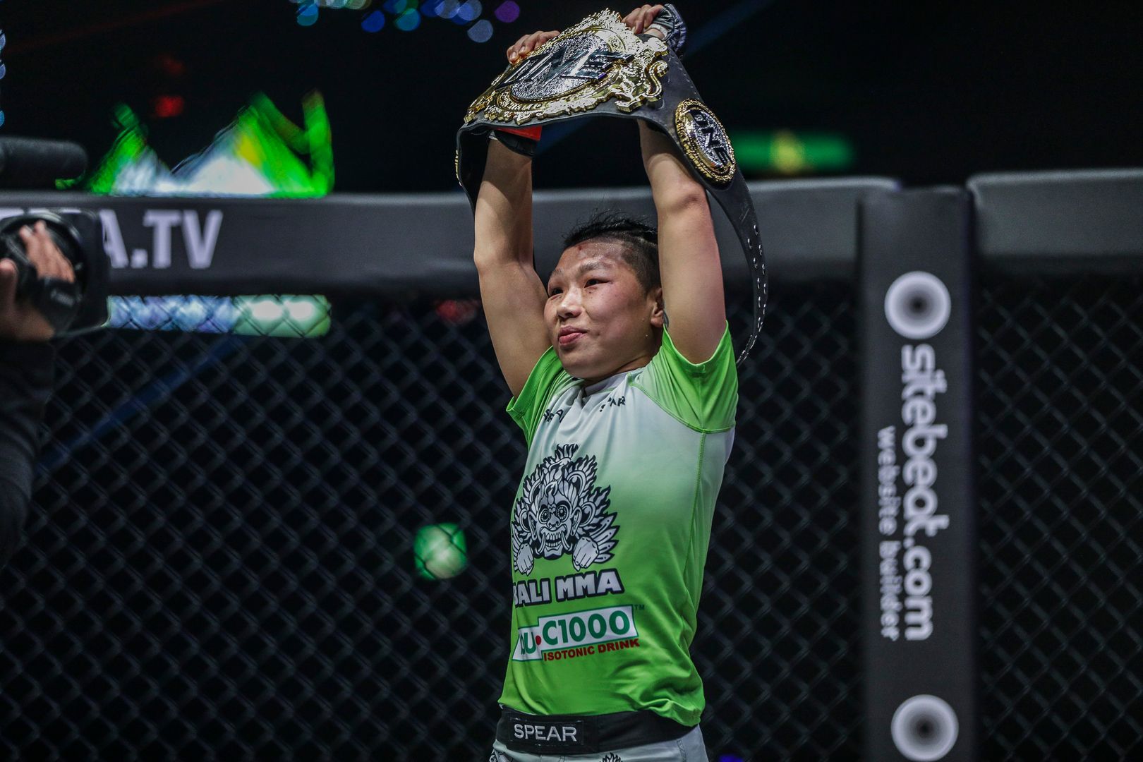 Xiong Jing Nan proudly raises the ONE Women's Strawweight World Championship belt