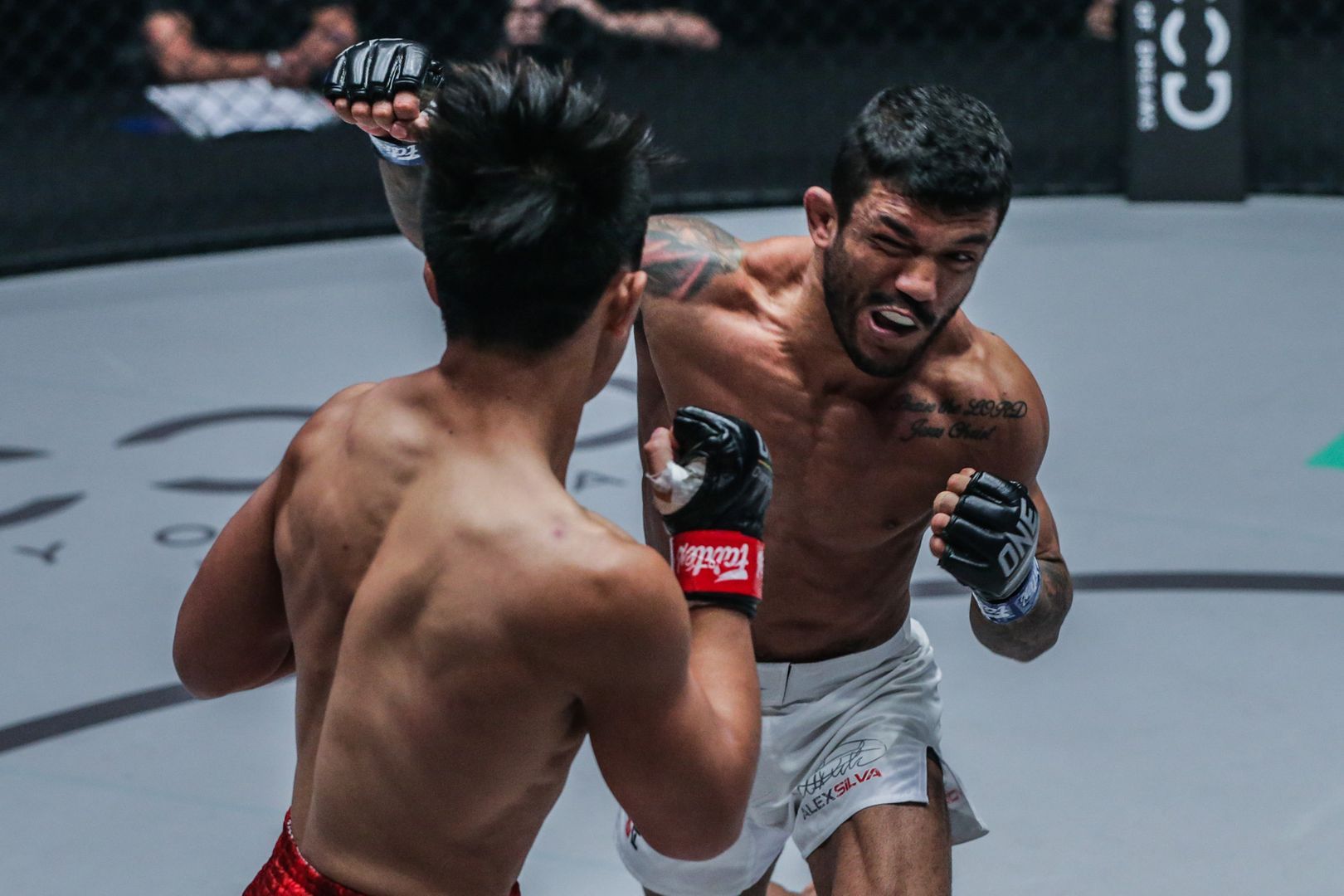 Brazilian mixed martial artist Alex Silva bites down on his mouthguard and hits Joshua Pacio
