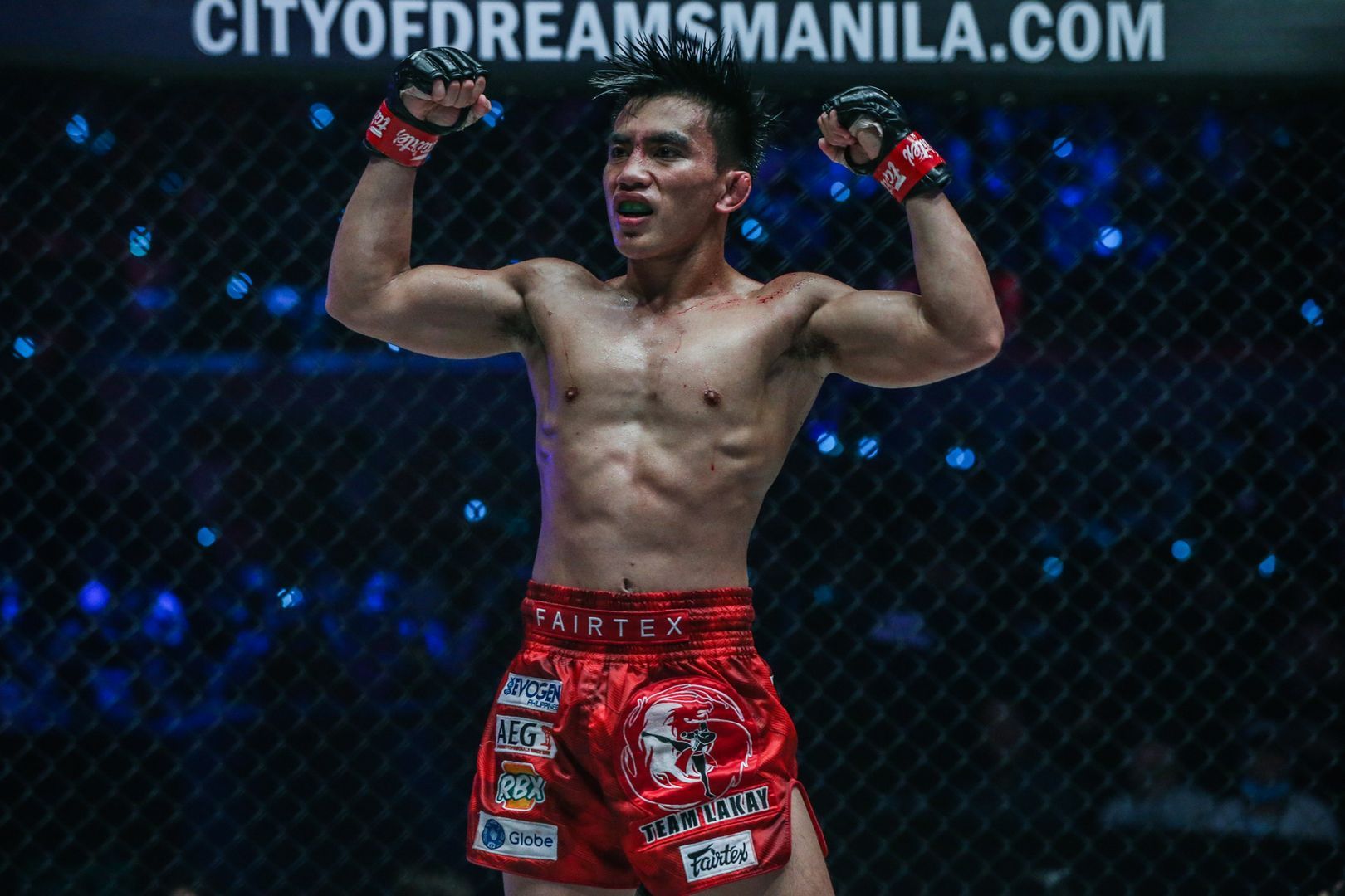 Joshua Pacio flexes after retaining his strawweight gold at ONE: FIRE & FURY.