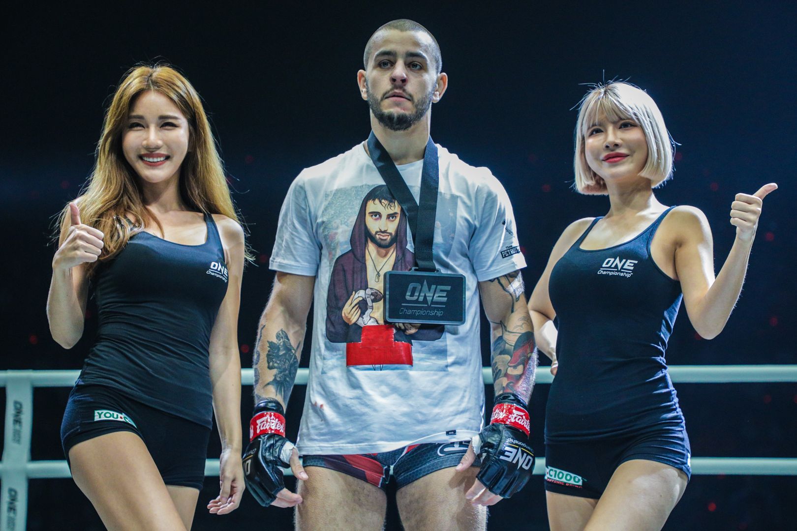 Unbeaten lightweight contender Iuri Lapicus poses with the winner's medal and the ring girls
