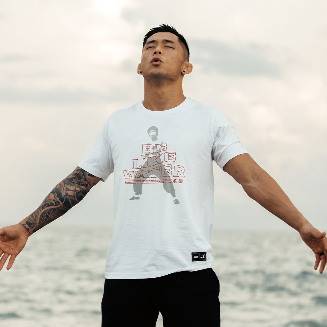 Martin Nguyen poses in the Be Like Water tee from the ONE X Bruce Lee Collection from ONE.SHOP!