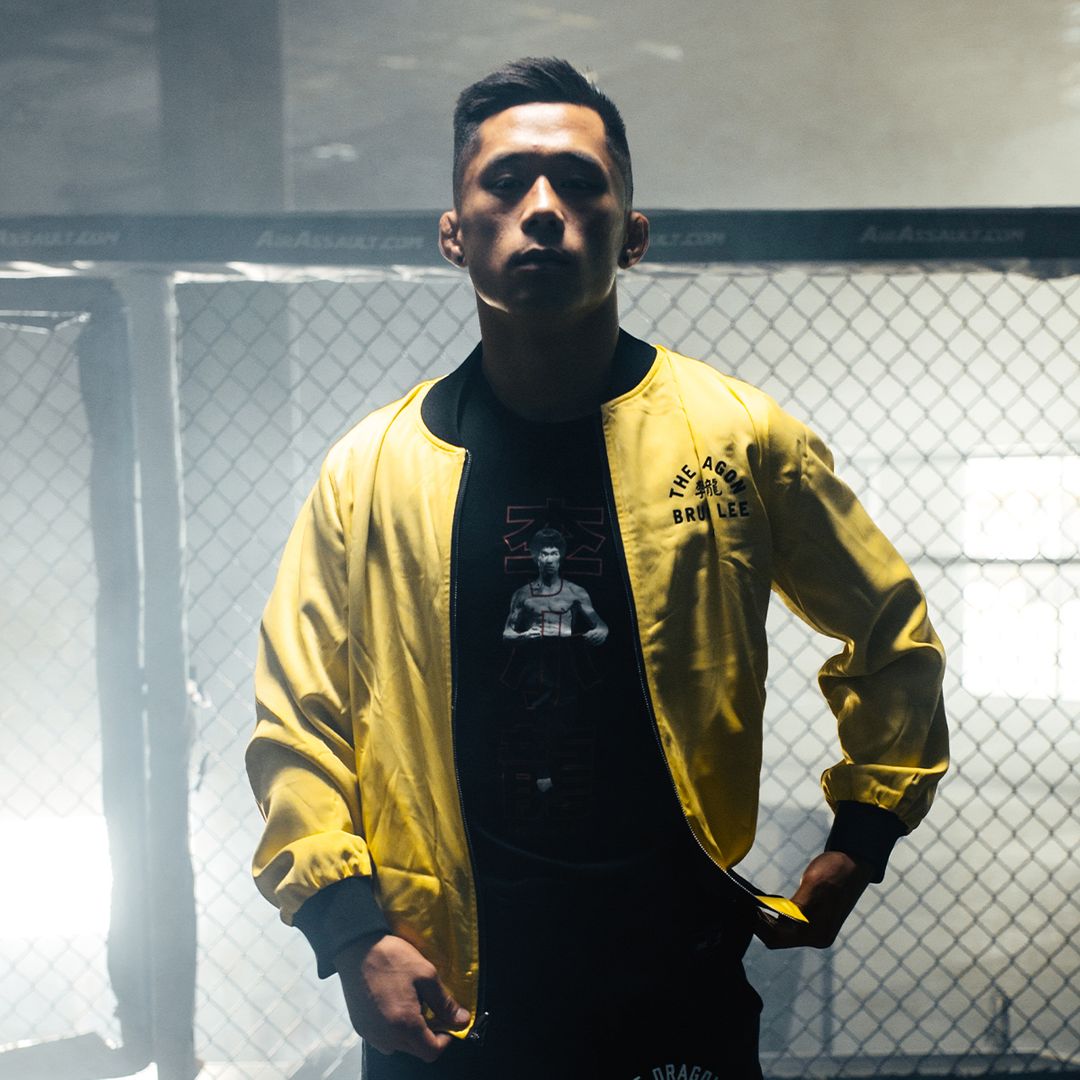 Martin Nguyen poses in the reversible bomber jacket from the ONE X Bruce Lee Collection from ONE.SHOP!