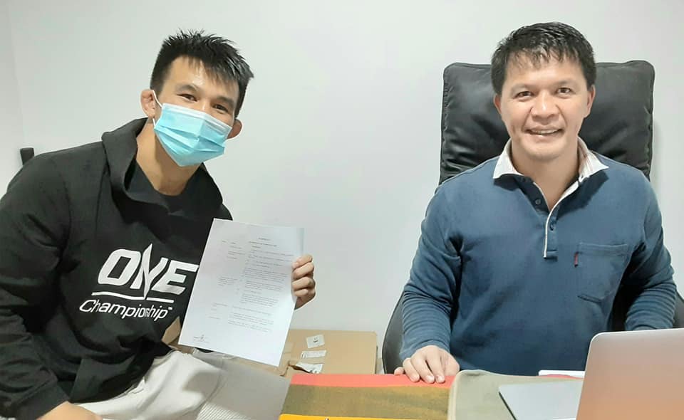 MMA fighter Jeremy Pacatiw signs his ONE Championship contract in Mark Sangiao's office